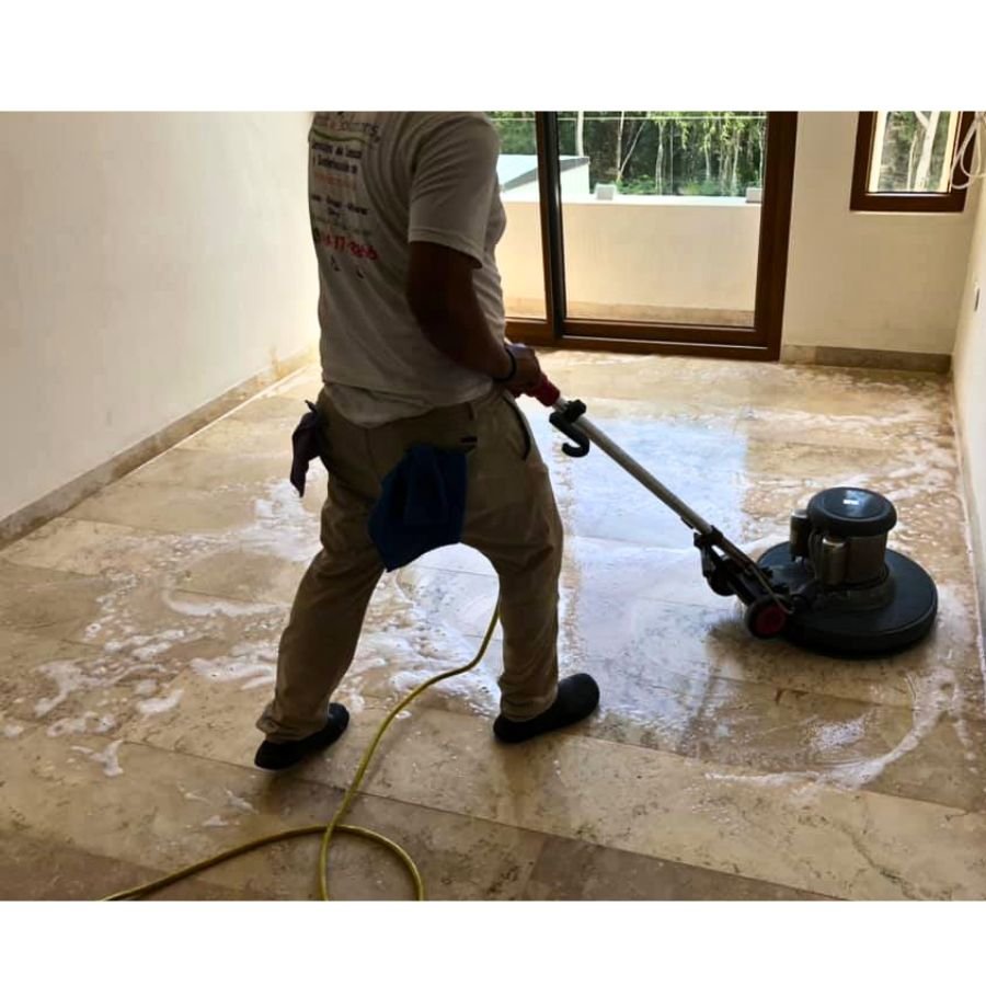 Operador realizando pulido profesional de piso de mármol con maquinaria industrial en Tulum