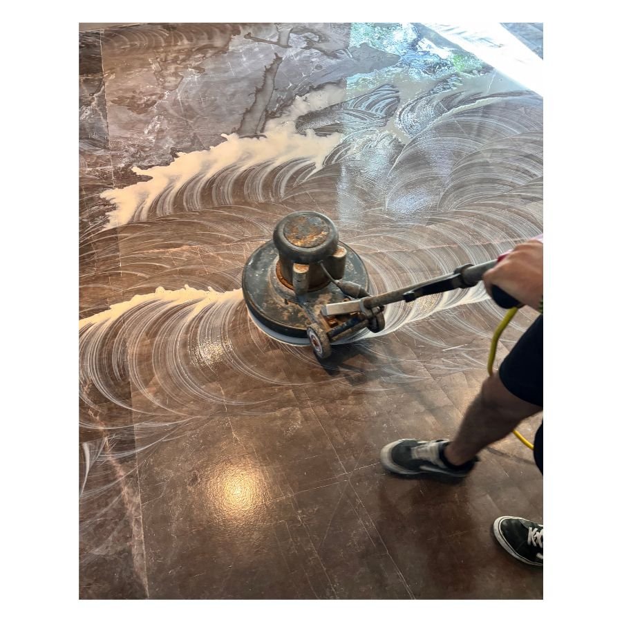 Operador realizando proceso de pulido de pisos con máquina rotativa y espuma profesional en Tulum.