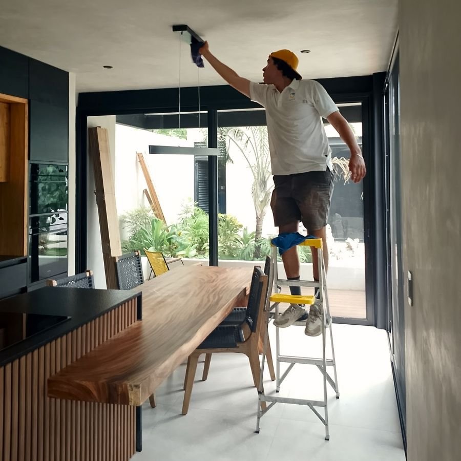 Técnico de Sanit Solutions realizando limpieza de plafón para eliminar polvo fino de construcción en una propiedad de Tulum.